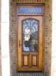 фото деревянные однопальные кованые двери со стеклом